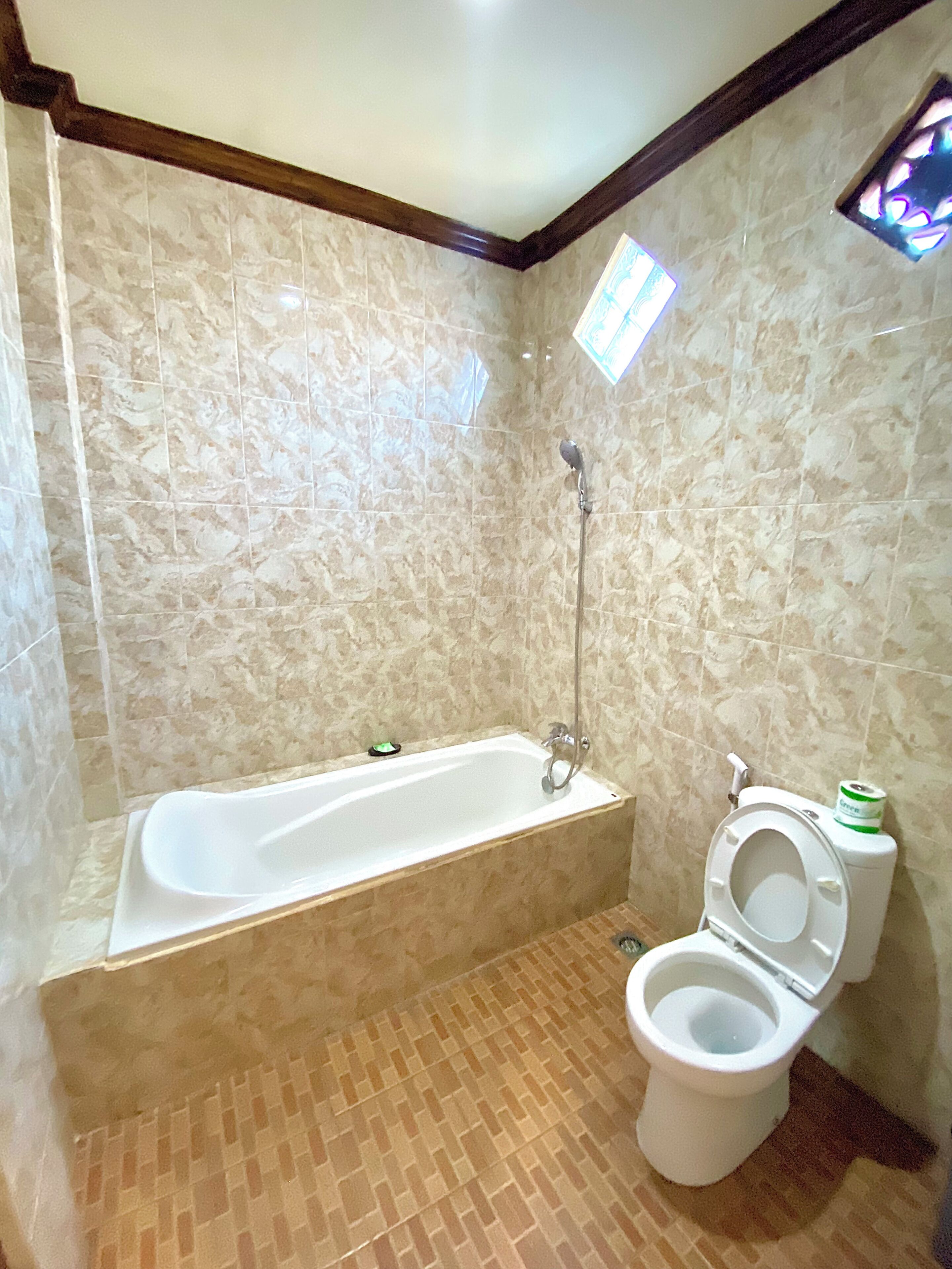A bathroom with a bathtub, toilet, and shower.