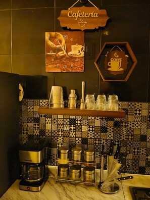 Ein Kaffee-Bereich mit Kaffeemaschine, Zucker, Milch und einem Schild mit Kaffeemotiv.