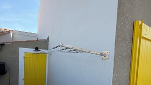 Un callejón estrecho con una puerta amarilla y una pared blanca.