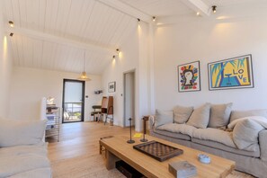 A spacious living room with a wooden coffee table, a sofa, and a bookshelf.