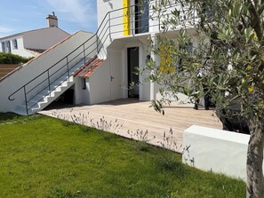 A modern house with a white exterior, a wooden deck, and a staircase leading to a yellow door. - Le Vieil · Renovated house · Beach & sea view (Noirmoutier-en-l'Île)
