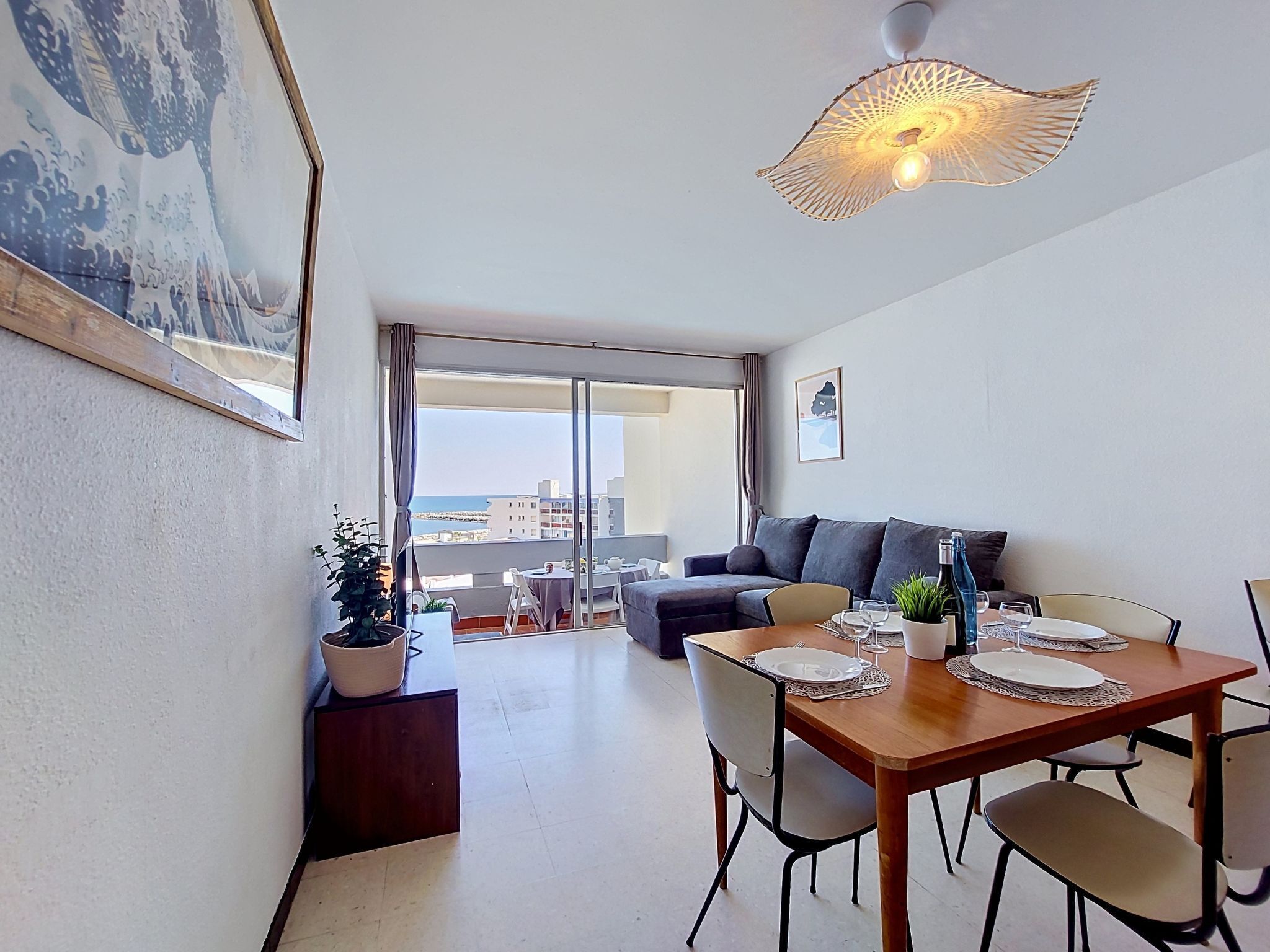 A modern living room with a dining area, large windows, and a view of the city.