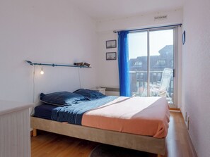 Ein Schlafzimmer mit Bett, einem Fenster mit Blick und einem Deckenventilator.