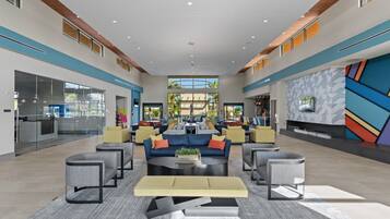 A spacious lobby with a central seating area, large windows, and a modern geometric wall design.