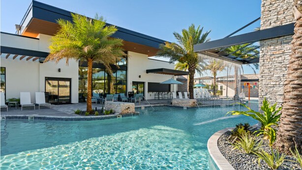 A modern pool area with lounge chairs and palm trees. - Luxury 5BR/5BA - Villa at Paradiso Grande Near Universal, Sea World and more (Orlando)