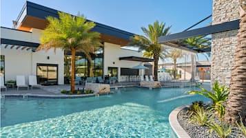 A modern pool area with lounge chairs and palm trees.
