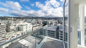 Un edificio alto con vistas a un paisaje urbano, que incluye varios edificios y un cielo despejado.