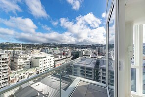 A high-rise building with a view of a cityscape, including various buildings and a clear sky. - 2BR Skyline Views - Cozy HydeLane Stay w Amenities (Wellington)
