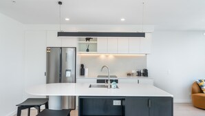 Una cocina moderna con una isla central, electrodomésticos de acero inoxidable y un diseño minimalista.
