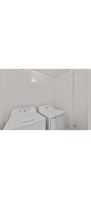 Une buanderie équipée de deux machines à laver blanches.