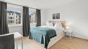 Una camera da letto con un letto, un comodino e una finestra con tende.