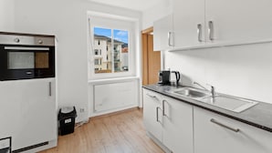 Una cucina moderna con forno a incasso, lavello e finestra vista edifici.