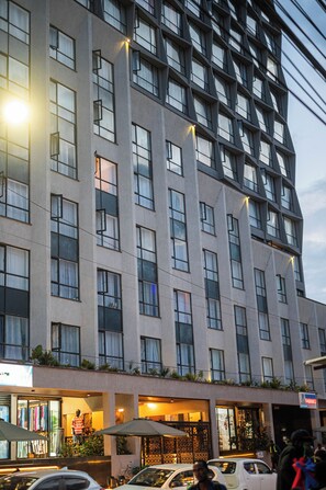 A multi-story hotel with a modern facade, large windows, and outdoor seating areas. - Enjoy a soothing stay in a modern apartment in Nairobi. (Nairobi)