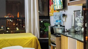 Une chambre à coucher de taille modeste, comprenant un lit, une petite table et une fenêtre avec des rideaux.