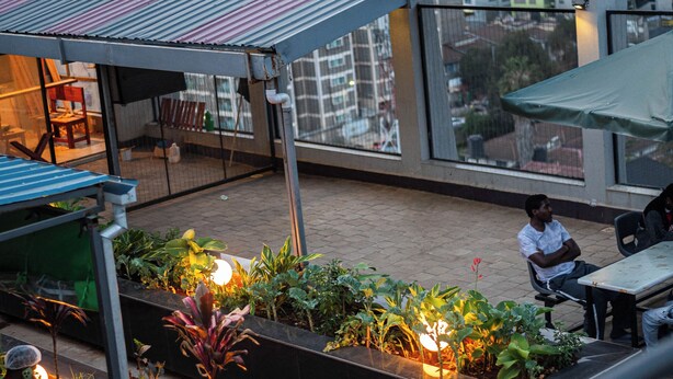 Une terrasse sur le toit offrant une vue sur la ville, des espaces de détente en plein air et un jardin.