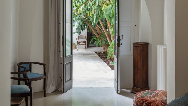 An interior hallway leading to a room with a bed, a chair, and a wooden cabinet. - Large charming house in Puglia, not far from the Ionian Sea. (Nardò)