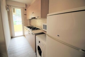 Eine Küche mit Waschmaschine, Herd und Kühlschrank.