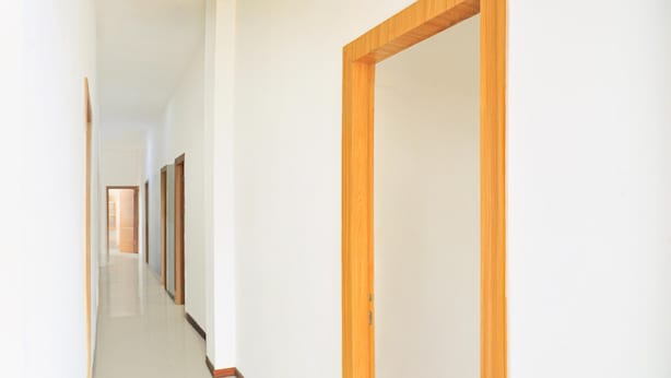 A long, narrow hallway with wooden doors and white walls. - Cozy Twin Escape With Free Wifi and Parking (Bukittinggi)
