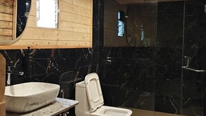 A bathroom with wooden ceiling, a marble sink, a toilet, and a glass shower enclosure. - Karibu Resort Karjat (Karjat)
