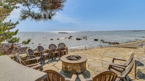 Eine Terrasse mit Steinbelag, Sitzgelegenheiten im Freien und einer Feuerstelle.