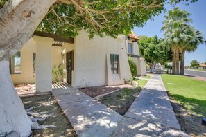 A residential building with a covered porch, a pathway leading to the entrance, and a well-maintained lawn. - Yuma Desert Oasis: Pool & Remote Work Setup! (Yuma)