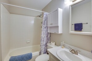 Een badkamer met een bad, toilet en wastafel.