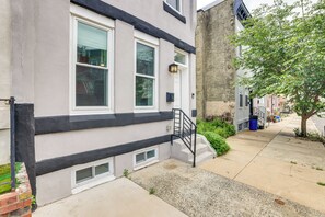 A townhouse with a black trim, a front door, a small window, a staircase, and a tree. - Walk to Fairmount Park: Modern Philly Townhome! (Philadelphia)