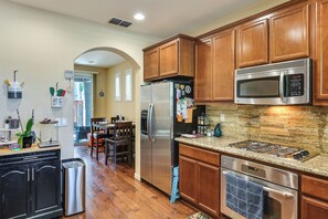 A kitchen with wooden cabinets, stainless steel appliances, and a granite countertop. - Spacious + Pet-Friendly Family Home in Tracy (Tracy)