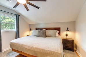 A bedroom with a bed, a nightstand, a lamp, a ceiling fan, and a window. - Fire Pit w/ Mtn Views! Blue Ridge Cabin Retreat (Blue Ridge)