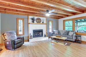 A living room with a fireplace, a leather recliner, a gray sofa, and wooden floors. - Fire Pit w/ Mtn Views! Blue Ridge Cabin Retreat (Blue Ridge)
