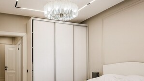 A bedroom with a bed, wardrobe, and a chandelier. - Luxury Cozy 1-bedroom 4 people space in the heart Bishkek with AC (Bishkek)