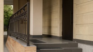 A building entrance with a staircase leading to a door marked 'COMPLIMENTS'. - Luxury Cozy 1-bedroom 4 people space in the heart Bishkek with AC (Bishkek)