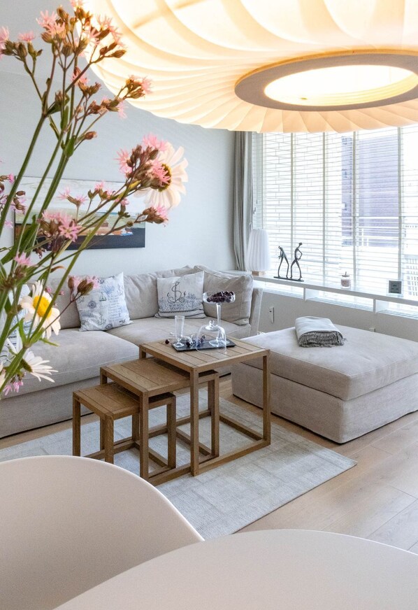 Ein modernes Wohnzimmer mit einer Couch, einem Couchtisch und einer Lampe.
