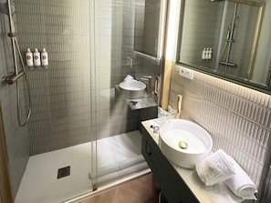 A bathroom with a glass-enclosed shower, a sink, and a mirror. - Holiday Home - Detached (Alicante)