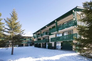 A multi-story building with balconies, a snow-covered ground, and a clear sky. - Premium Alpine Family Retreat with Mountain Charm (Bolquere Pyrénées 2000)