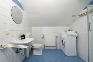 A bathroom with a sink, toilet, and washing machine. - FarawayHomes Studio Leoben K105 (Donawitz)