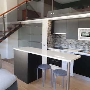 A modern kitchen with a central island, a microwave, and a built-in oven.