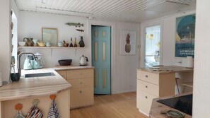 A kitchen with a blue door, wooden cabinets, and a coffee maker. - En perle på Møn nær sandstrand. God til 2 familier. kæledyrsvenlig (Askeby)