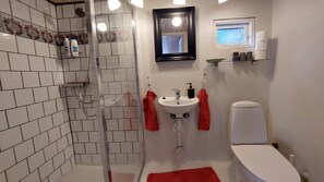 A bathroom with a glass shower enclosure, a white sink, a toilet, and a small window. - En perle på Møn nær sandstrand. God til 2 familier. kæledyrsvenlig (Askeby)