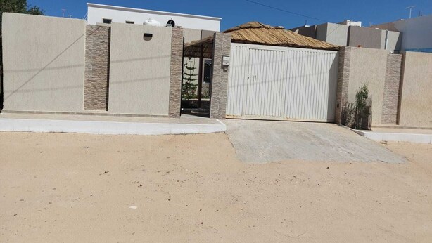 A gated residential area with a modern house, a gated driveway, and a clear sky. - COTE (Djerba - Houmt Souk)