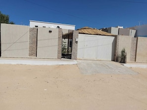 A gated residential area with a modern house, a gated driveway, and a clear sky. - COTE (Djerba - Houmt Souk)