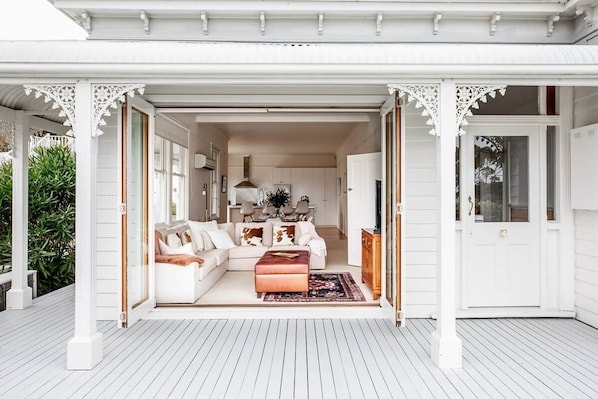 An open-plan living area with a sofa, ottoman, and dining table.