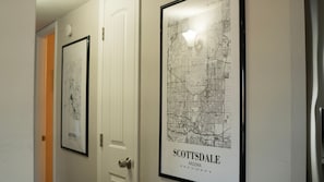 A hallway with framed maps of Scottsdale, Arizona, and a door with a doorbell. - 4-bdrm home with 2 Master Suites & Heated Pool minutes from Old Town Scottsdale (Scottsdale)