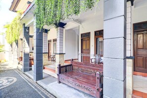 A building with a wooden bench outside, a stone pillar, and a door with a number. - Stylish Double Suite Escape W/ Free Wifi (Kedonganan)