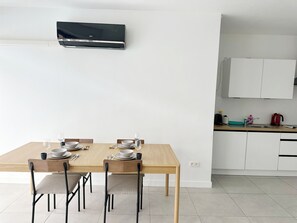 Eine moderne Küche mit weißen Schränken, einem Holztisch und Stühlen.