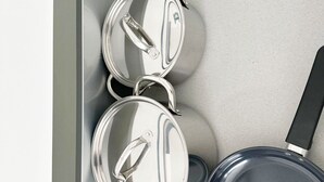 Een keuken met roestvrijstalen pannen en een koekenpan.