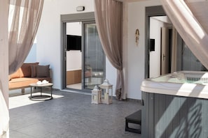 Ein Balkon mit einer Sitzecke, einem Whirlpool und zwei Laternen.