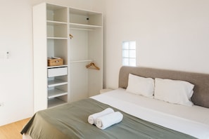 A bedroom with a bed, a wardrobe, and a window. - New 2BR Apartment near Dreamland Beach (Kuta)