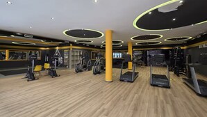Ett gym med löpband, crosstrainers och ett trägolv.