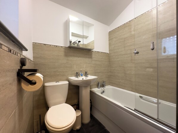 Une salle de bain avec des toilettes, un lavabo et une baignoire.